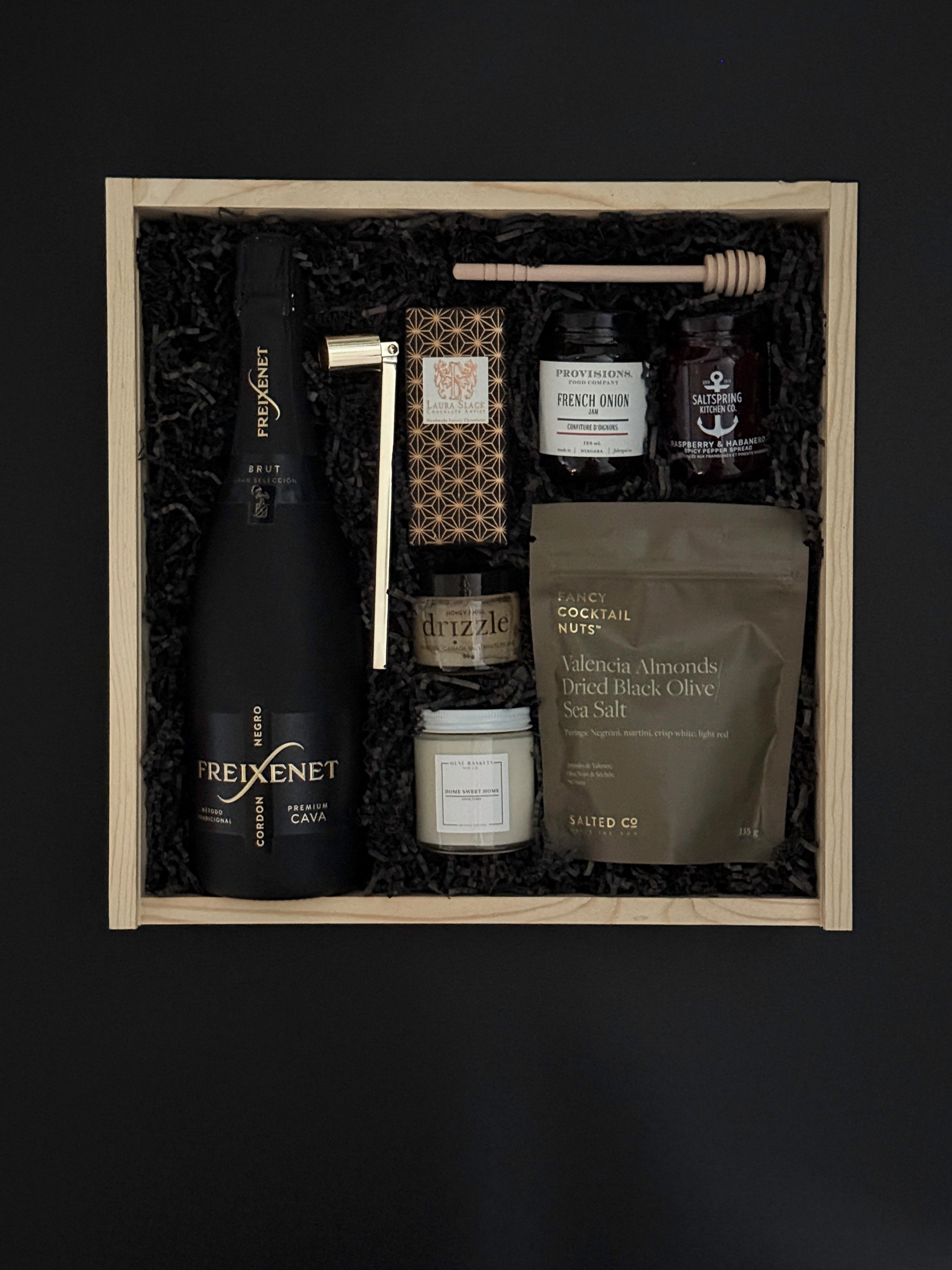 Corporate client gift box with sparkling wine, chocolate, almonds, and artisan candle.