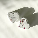 Two Reverie heart-shaped bath bombs with dried floral accents, a self-care product featured in Muse Baskets and Co. gift baskets