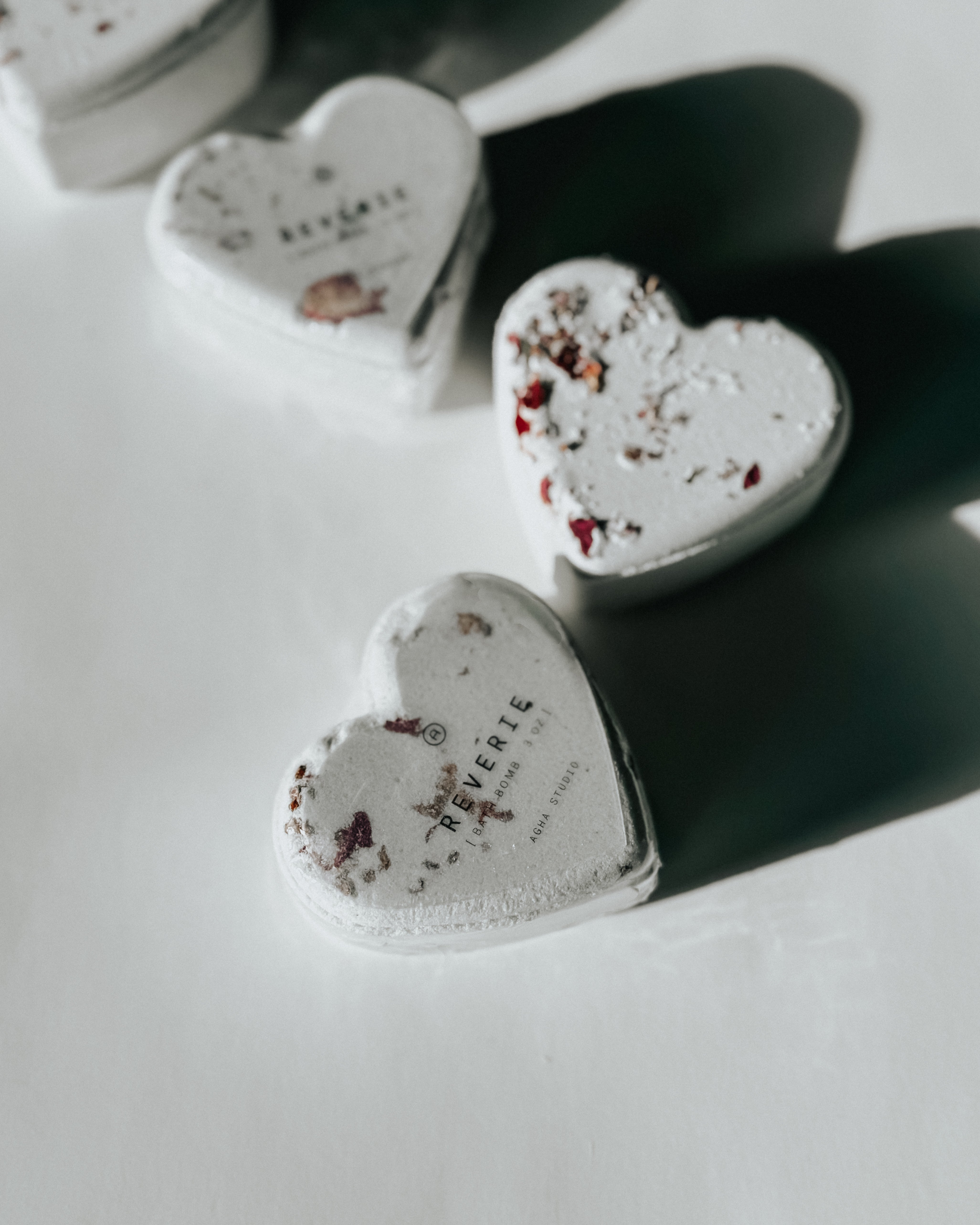 Reverie heart-shaped bath bombs decorated with dried flowers, a self-care product featured in Muse Baskets and Co. gift baskets