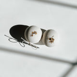 Two round bath bombs decorated with dried flowers and tied with twine, a self-care product featured in Muse Baskets and Co. gift baskets