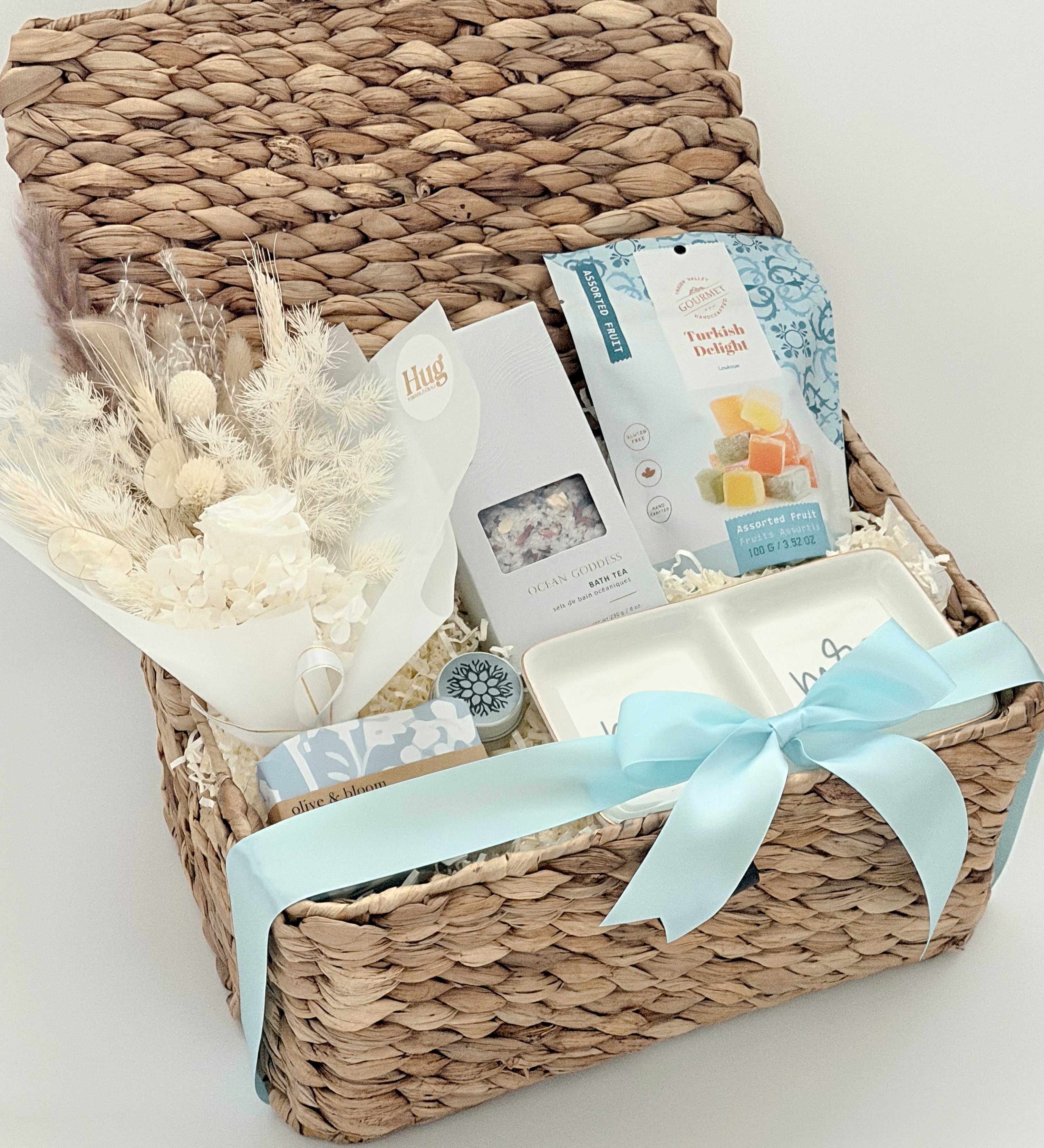 Woven gift basket with a white bow on a light background