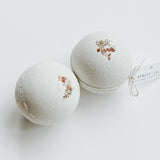 Two Spruce Calm bath bombs decorated with dried flowers, a self-care product featured in Muse Baskets and Co. gift baskets