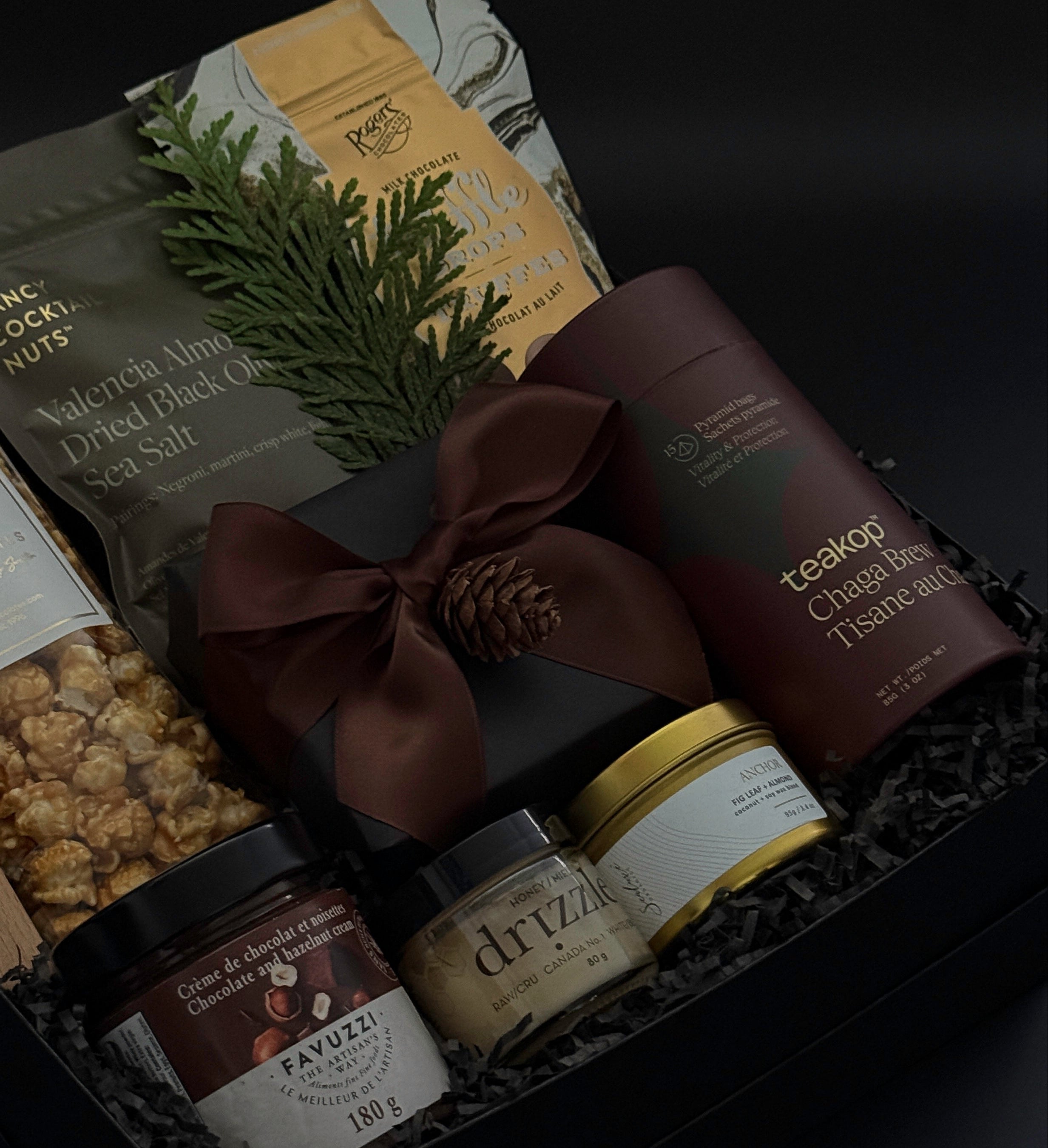 Elegant client appreciation gift box featuring sweet and savoury artisan foods and a gold tin candle.