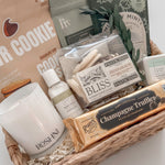 Close up of Quiet Comfort wicker gift basket featuring Rogers Chocolates champagne truffles and Roshni coconut soy candle