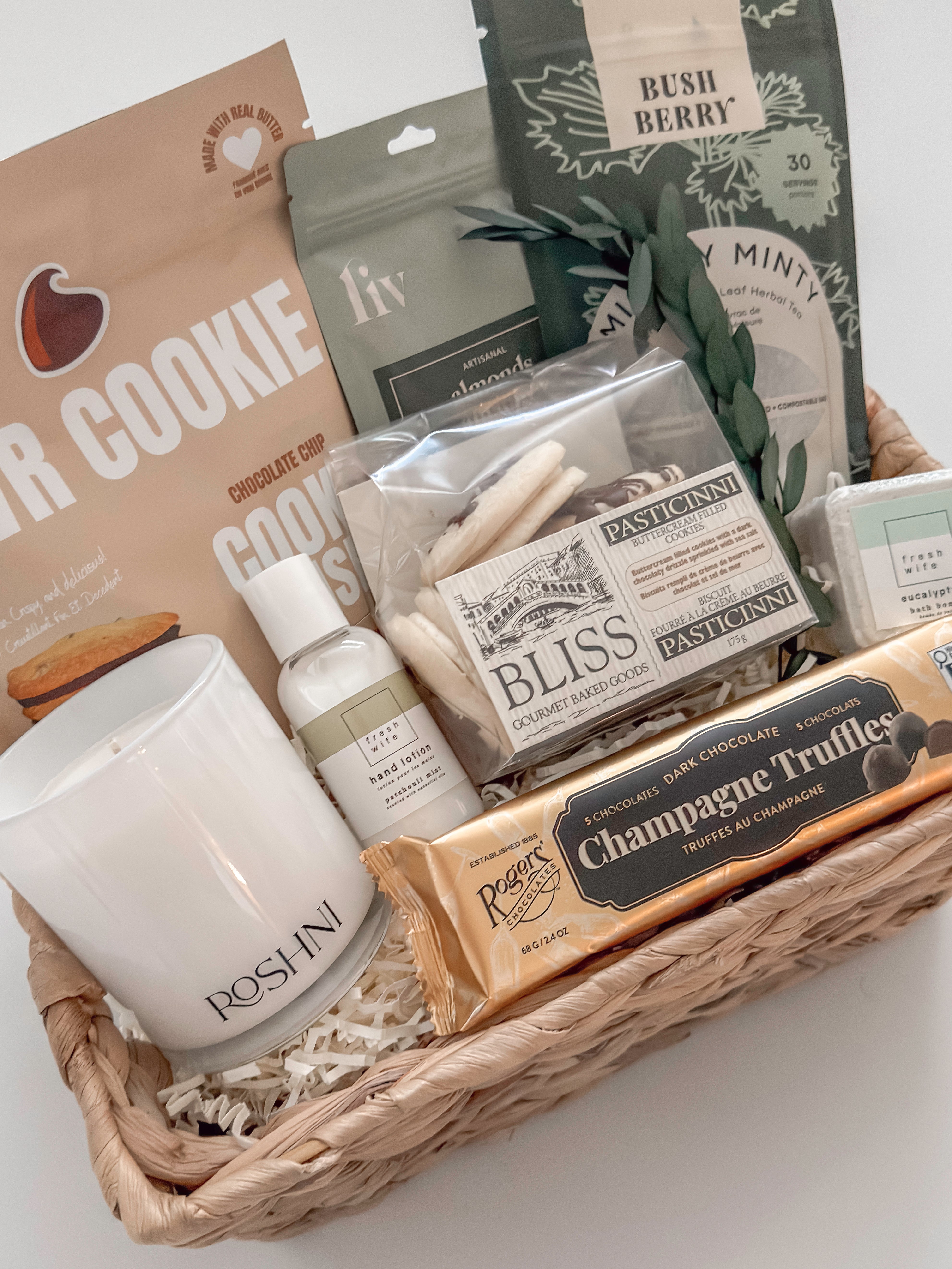 Close up of Quiet Comfort wicker gift basket featuring Rogers Chocolates champagne truffles and Roshni coconut soy candle