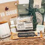 Gift basket with various items including cookies, pasticciini, and truffles on a white background