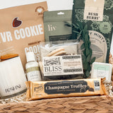 Gift basket with various items including cookies, pasticciini, and truffles on a white background