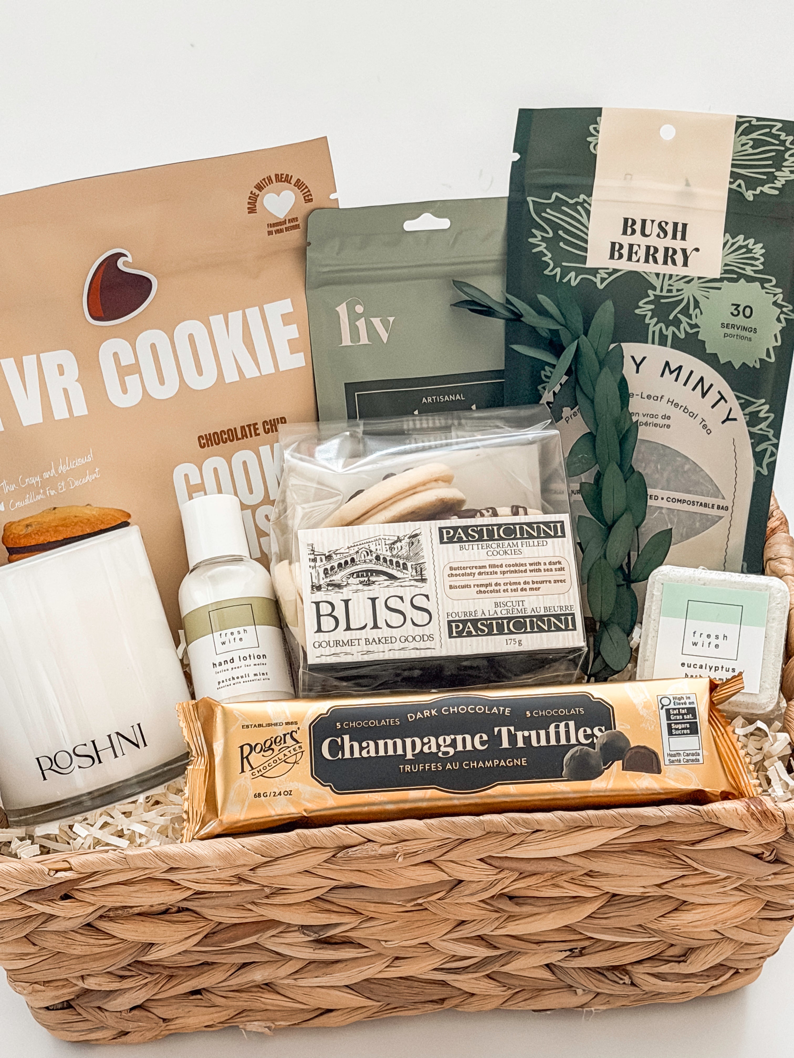 Gift basket with various items including cookies, pasticciini, and truffles on a white background
