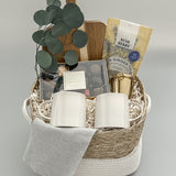 Luxury tea and chocolate gift basket with gold tea steeper, stoneware mugs, and Canadian artisanal treats, presented in a woven basket with satin ribbon