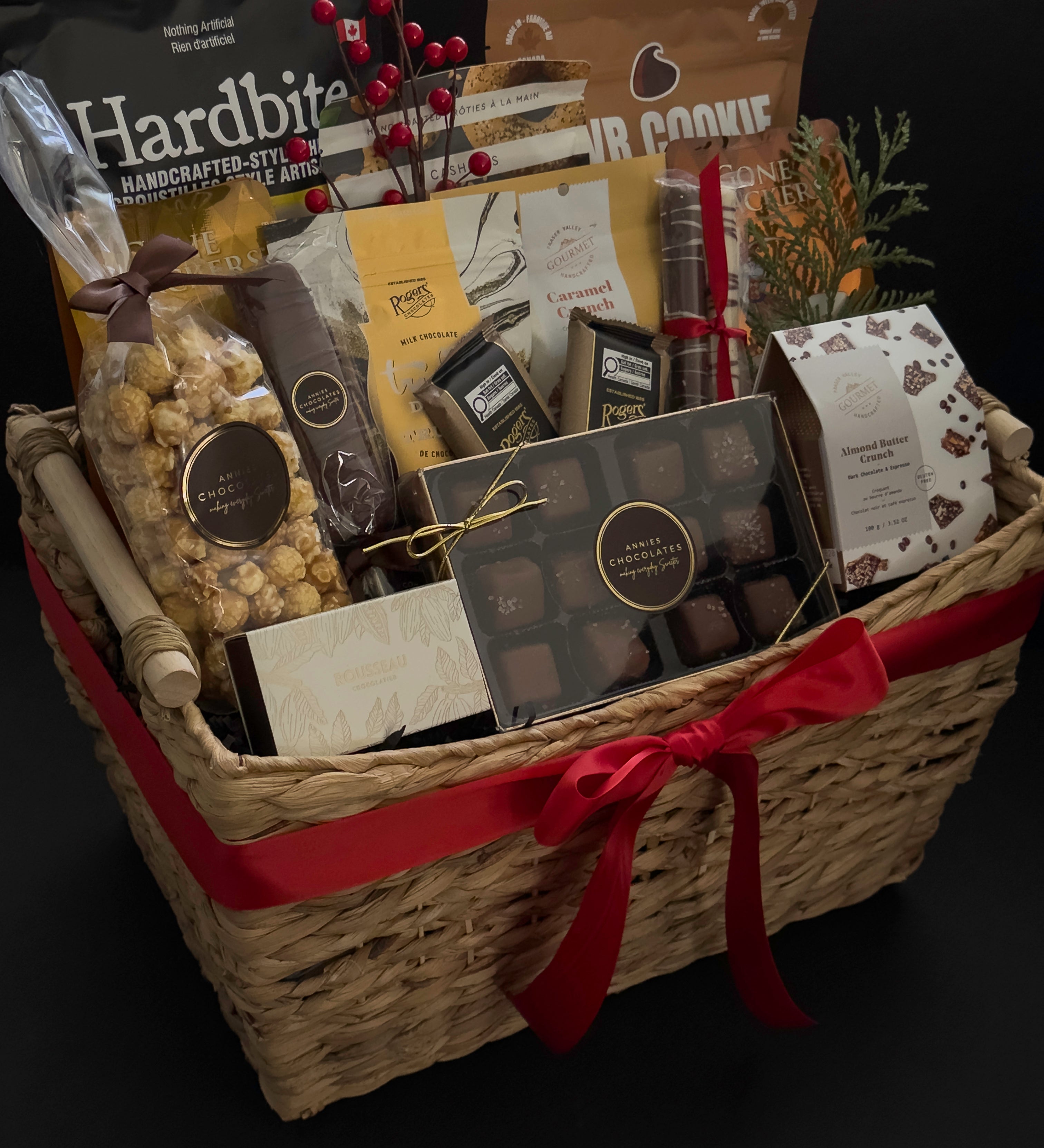 Woven holiday gift basket by Muse Baskets and Co. with Canadian-made chocolates, snacks, crackers and satin ribbon for client appreciation and employee gifting.