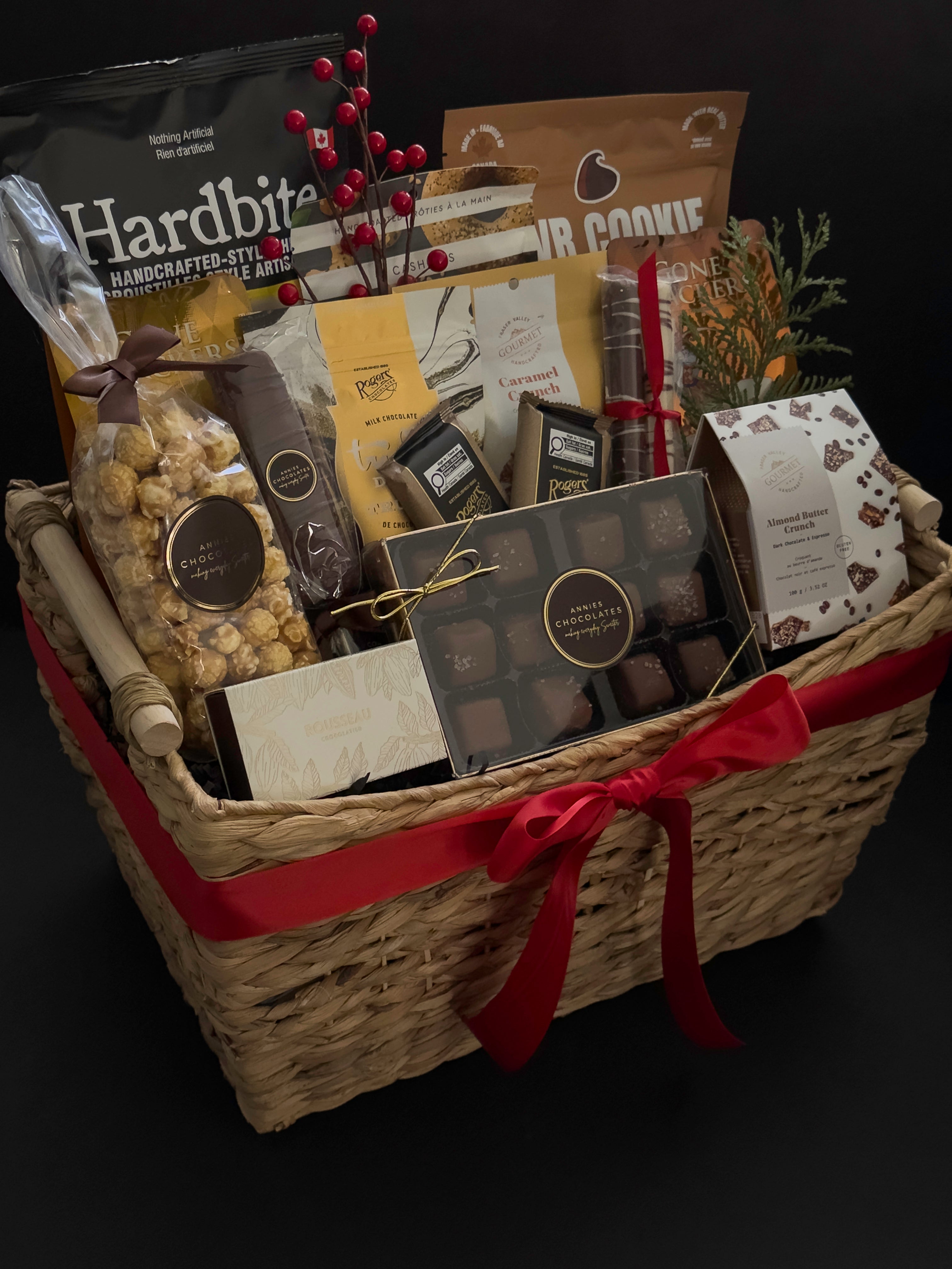 Woven holiday gift basket by Muse Baskets and Co. with Canadian-made chocolates, snacks, crackers and satin ribbon for client appreciation and employee gifting.