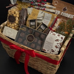 Corporate holiday gift basket by Muse Baskets and Co. featuring Canadian artisan treats, chocolates, popcorn, crackers and a polished woven basket presentation.
