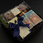 Flat lay of The Chocolate Indulgence gift box with cocoa, chocolate bar, cookies, and festive cinnamon bundle.