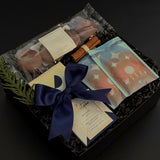 Flat lay of The Chocolate Indulgence gift box with cocoa, chocolate bar, cookies, and festive cinnamon bundle.
