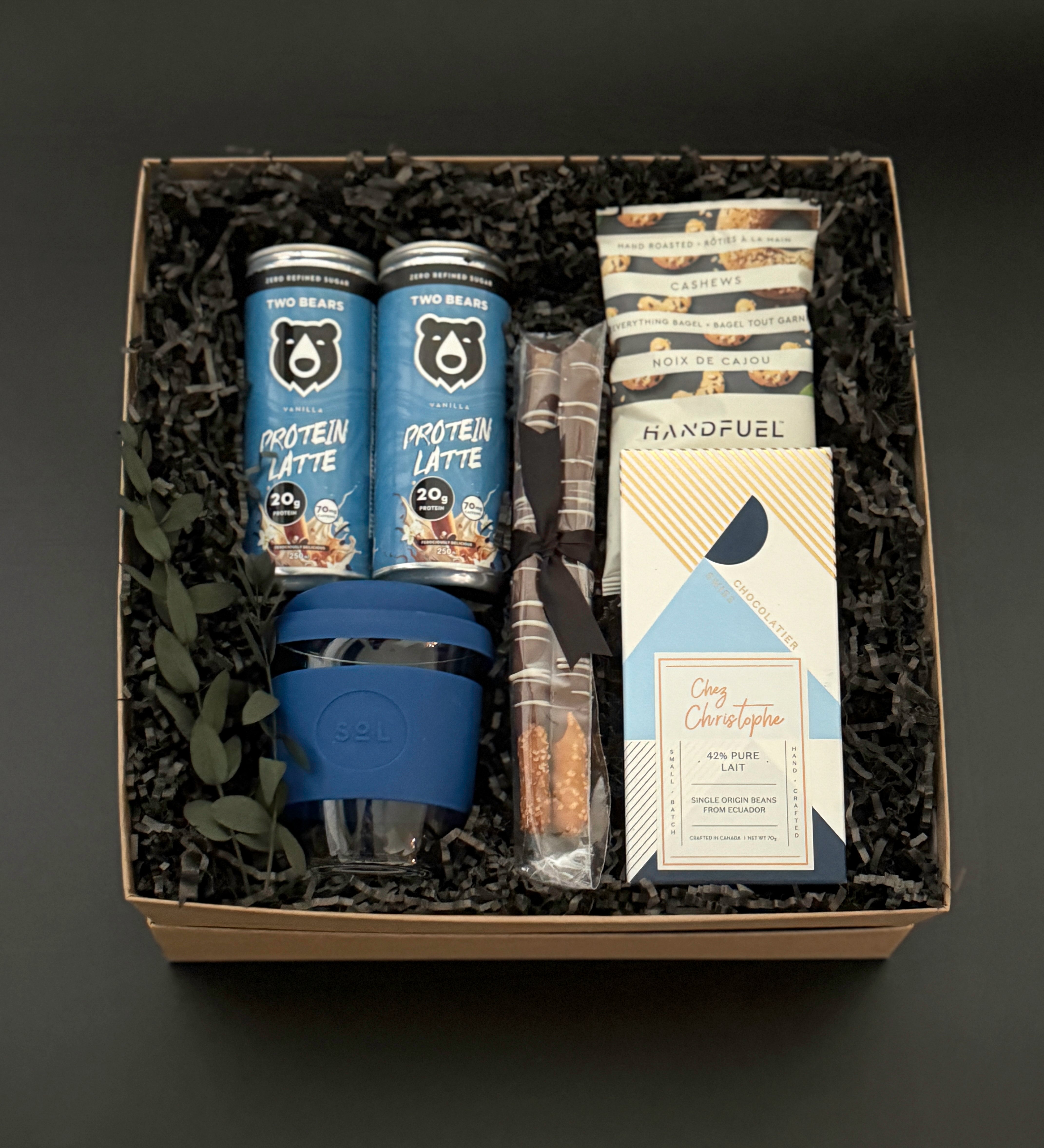 The Reset wellness gift box for men featuring protein lattes, cashews, chocolate, pretzel rods, and reusable travel cup – Muse Baskets & Co.