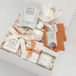 Gift set with bath products including a jar, soap, and bath bombs in a decorative box.