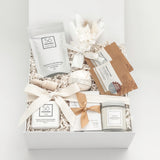 Gift box with skincare products and decorative elements on a white background