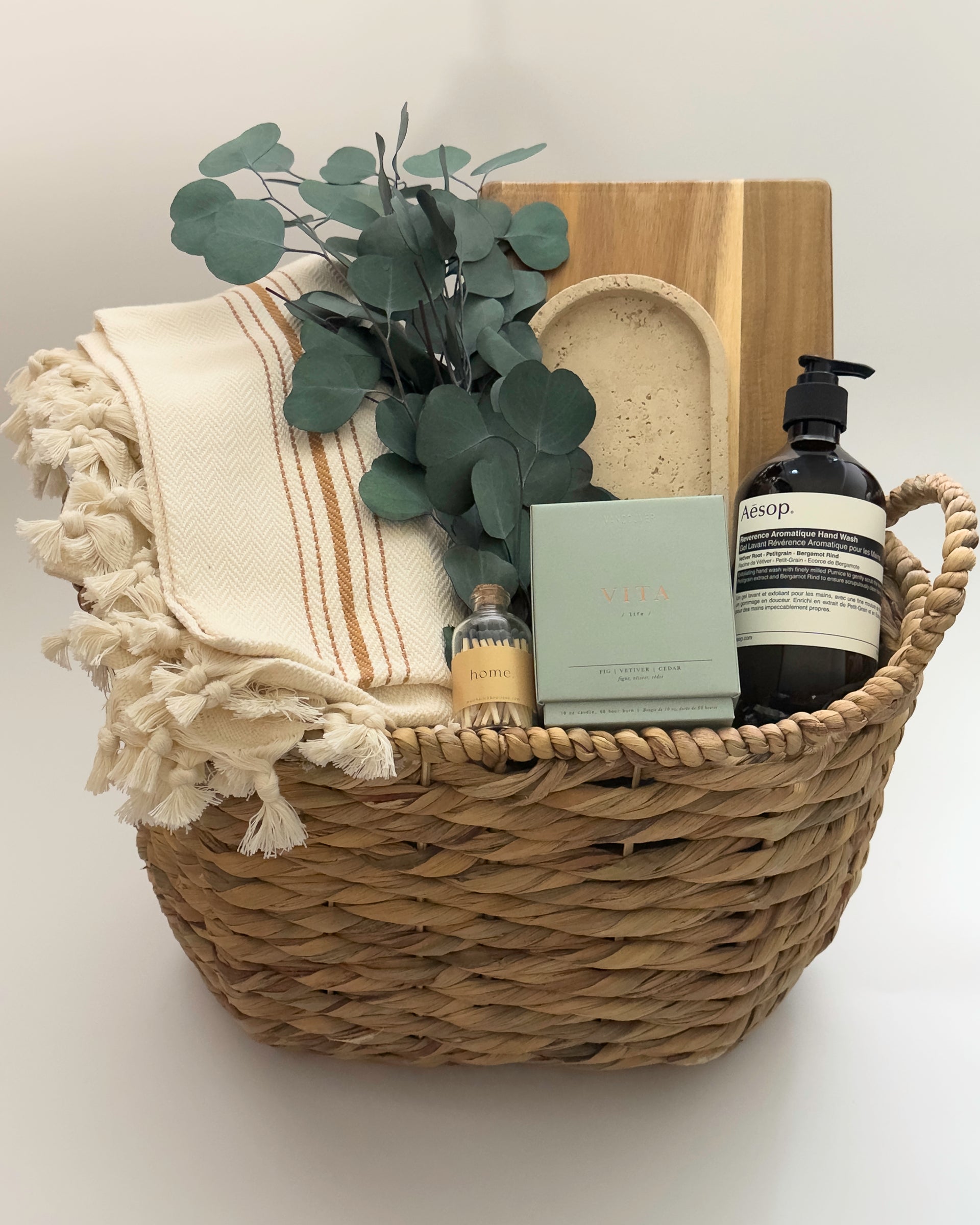 Luxury housewarming gift box Demeure by Muse Baskets Vancouver with acacia board travertine tray Turkish throw and Aesop hand wash