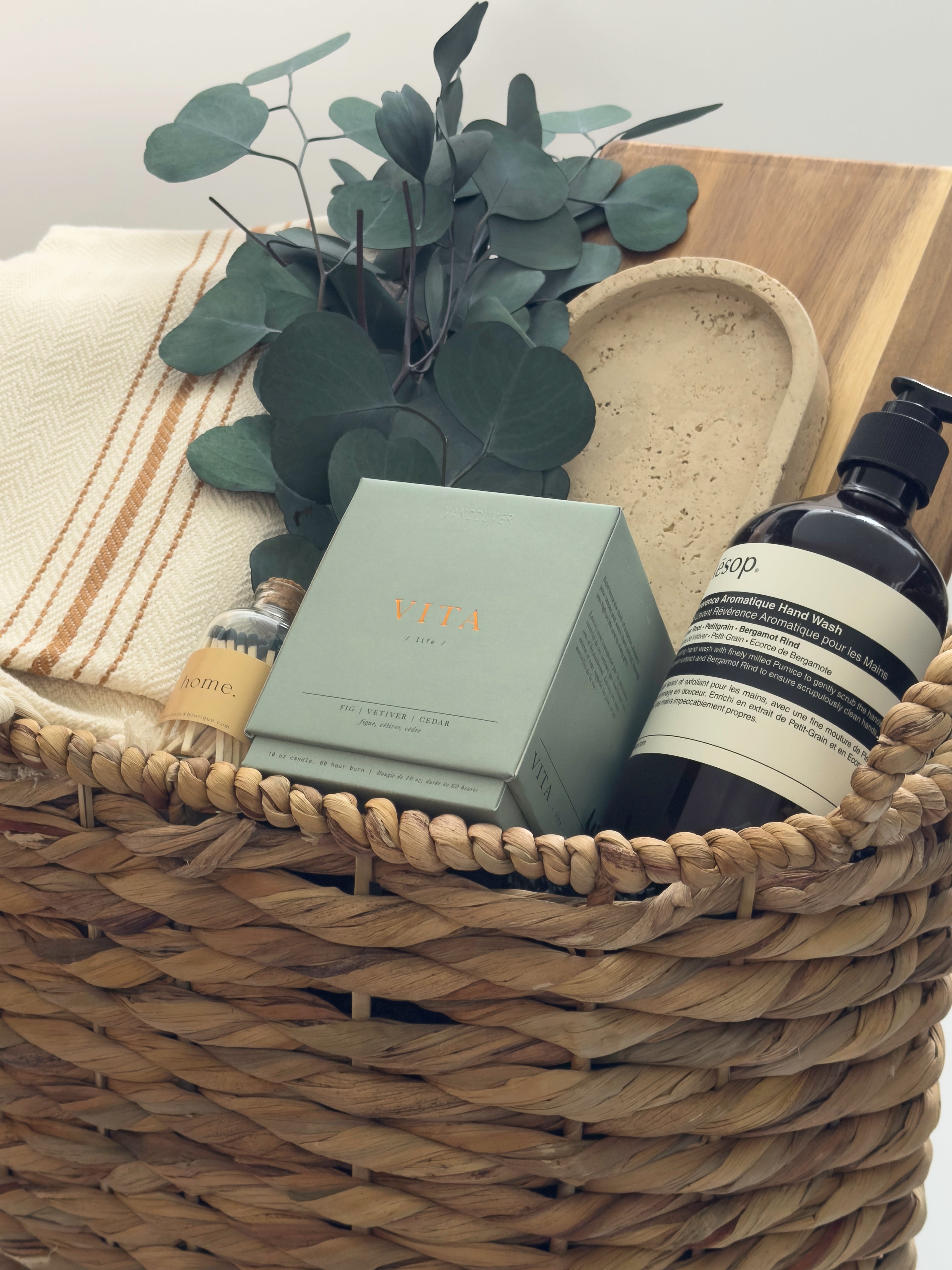 Luxury housewarming gift box Demeure by Muse Baskets Vancouver with acacia board travertine tray Turkish throw and Aesop hand wash