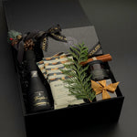 The Marlowe holiday gift box by Muse Baskets and Co. with truffles, cashews, almonds and candle in a signature onyx box.