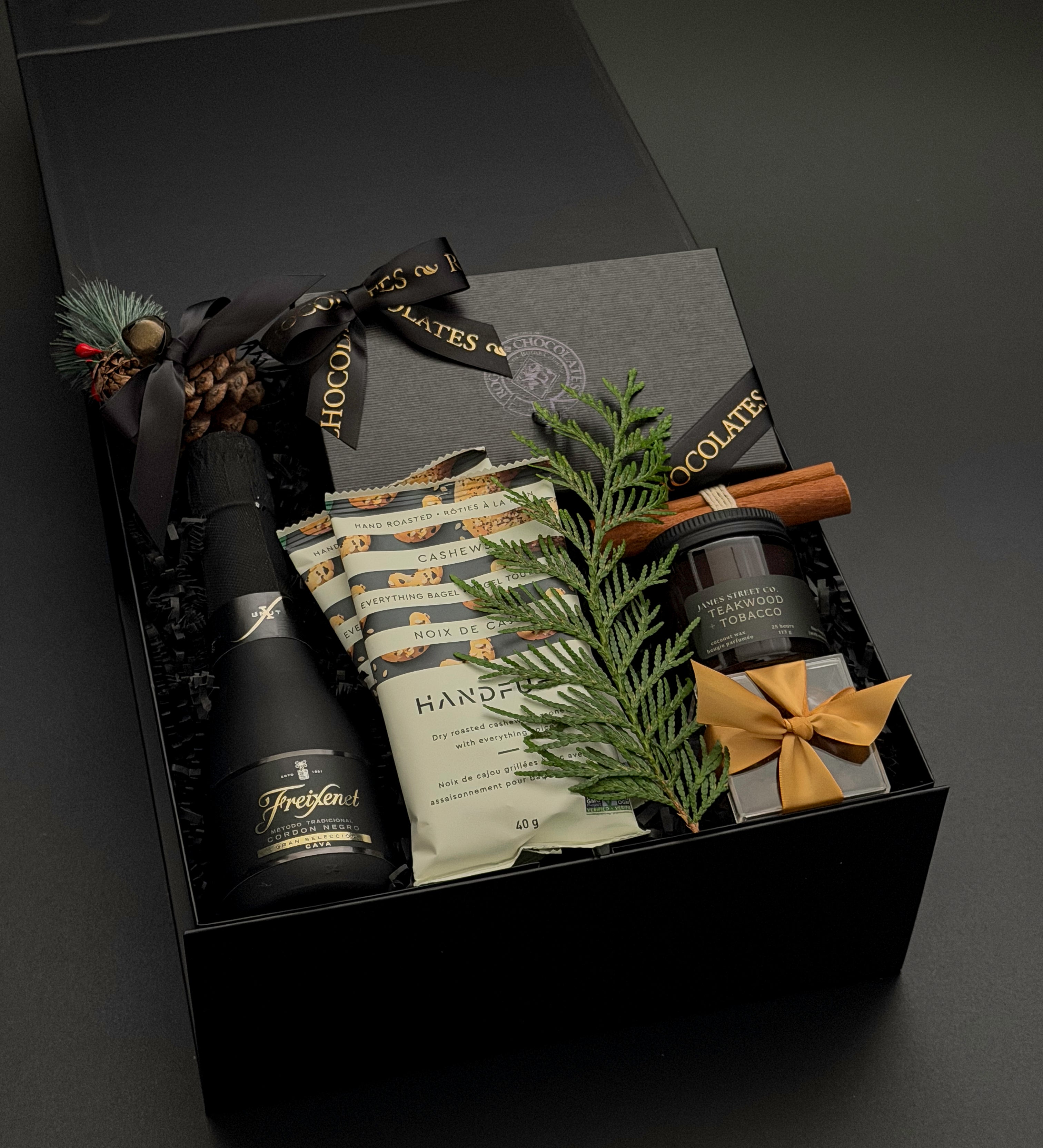 The Marlowe holiday gift box by Muse Baskets and Co. with truffles, cashews, almonds and candle in a signature onyx box.