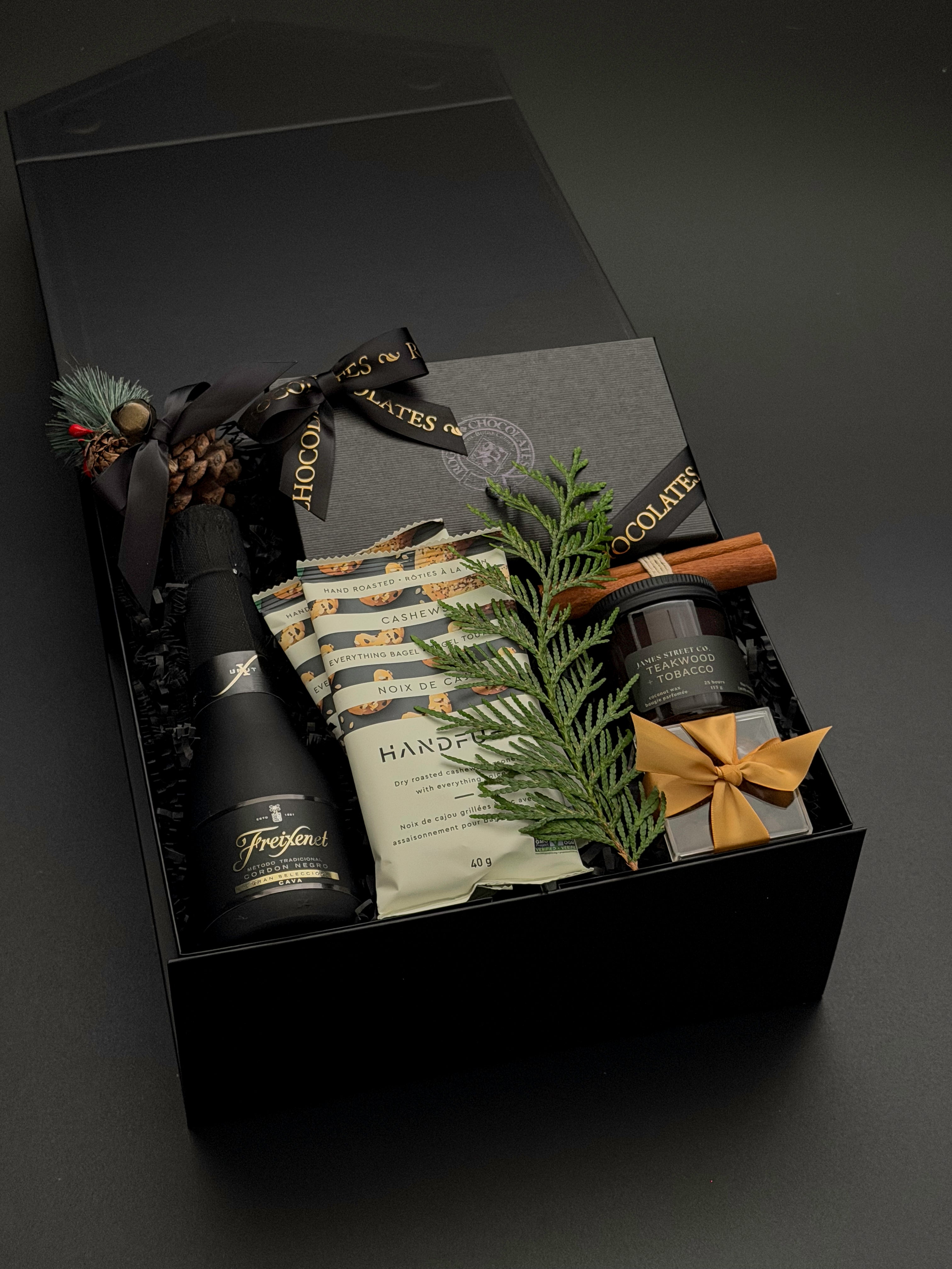 The Marlowe holiday gift box by Muse Baskets and Co. with truffles, cashews, almonds and candle in a signature onyx box.