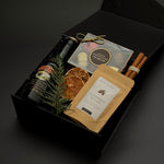 Holiday gift box by Muse Baskets and Co. featuring Baileys, Canadian chocolates, hot chocolate and cinnamon in a signature onyx presentation box.