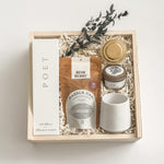 Warm Welcome new homeowner gift with tea, ceramic mug, home fragrance and candle, presented in Muse Baskets and Co.’s Signature Luxe Wood Gift Box.