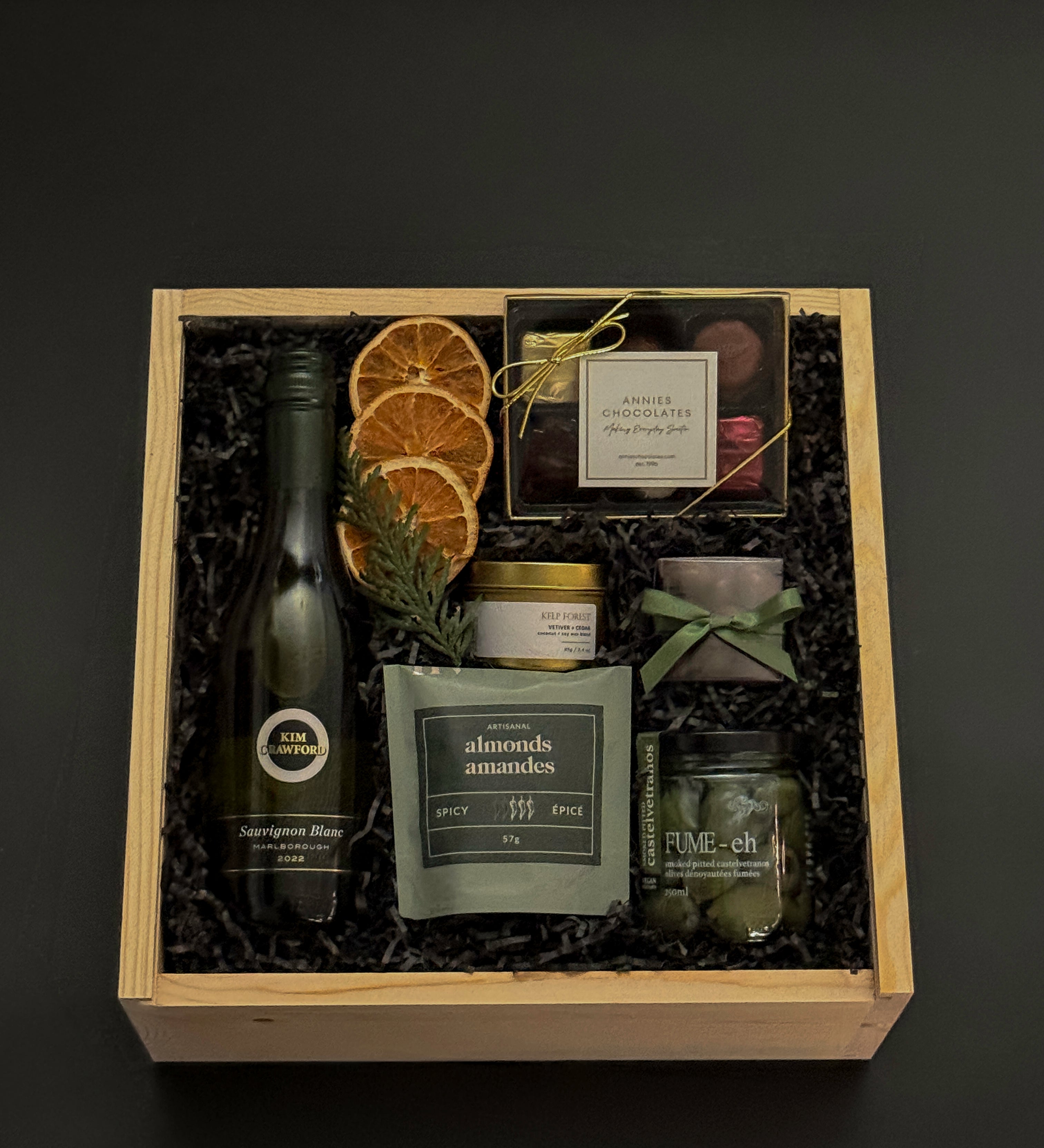 Eternal Glow holiday gift box with Sauvignon Blanc, chocolates, almonds, olives, and gold candle.
